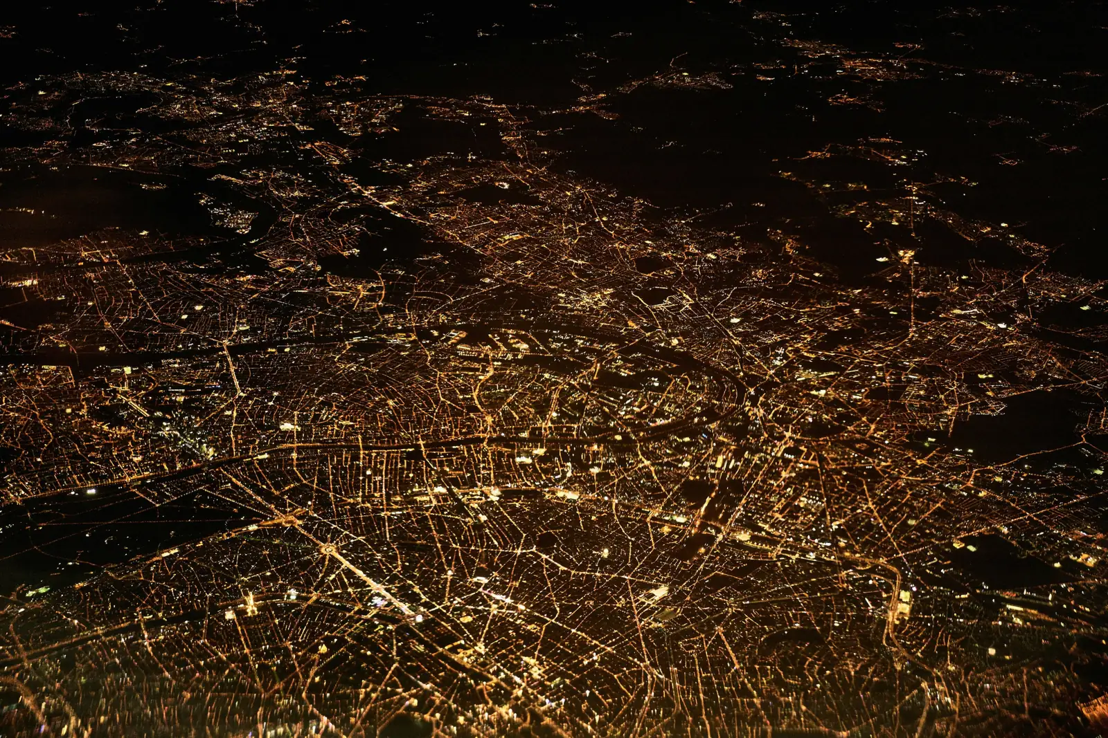 Aerial night view of a metropolitan area, its street grid picked out in light